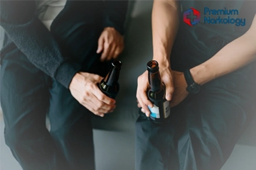 Парни сидят на корточках с бутылками